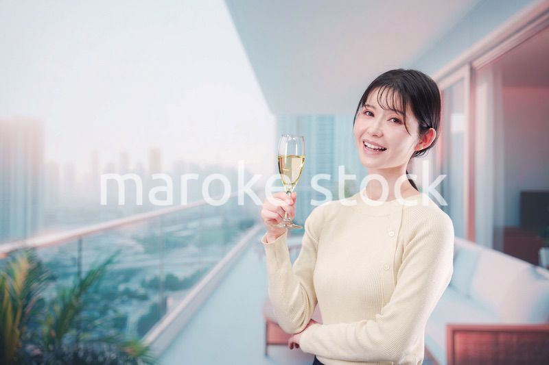 バルコニーでワインを愉しむ若い女性