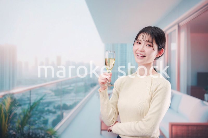 バルコニーでワインを愉しむ若い女性