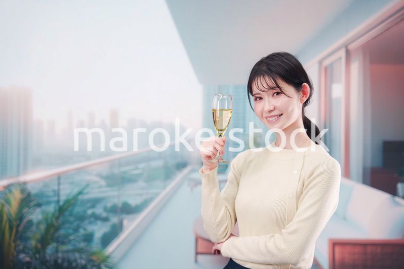 バルコニーでワインを愉しむ若い女性