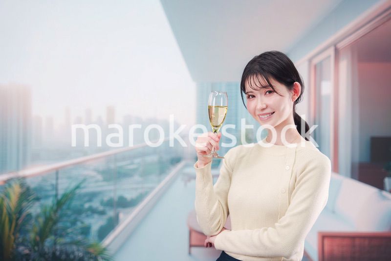 バルコニーでワインを愉しむ若い女性