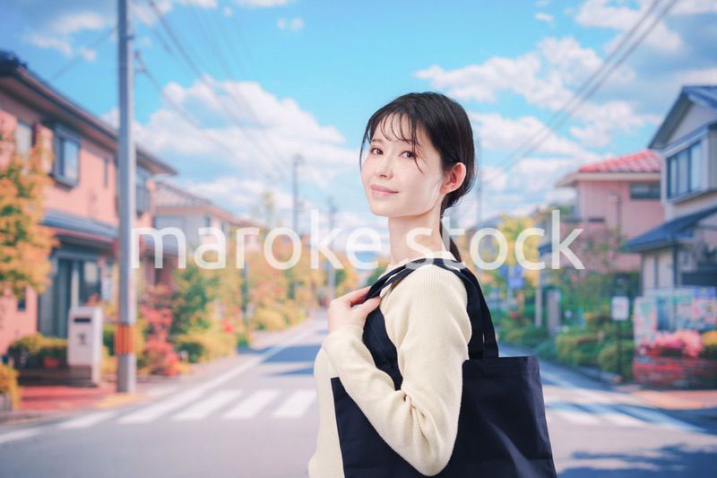 住宅街を歩く若い女性
