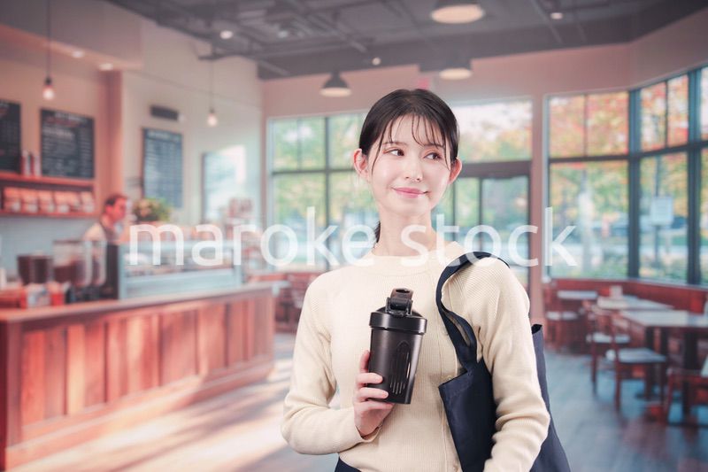 マイカップを持ってカフェに入る若い女性
