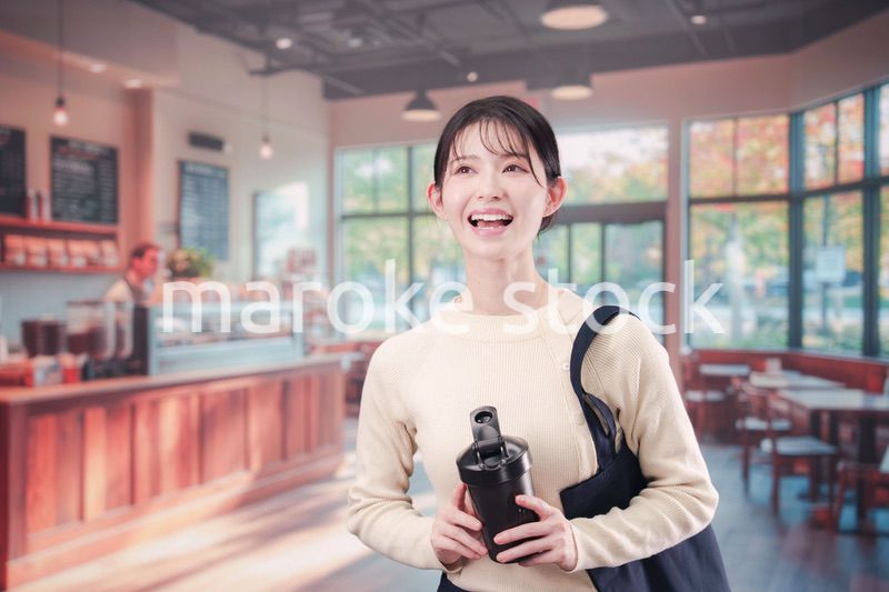 マイカップを持ってカフェに入る若い女性
