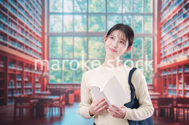 明るい図書館で本を読む若い女性