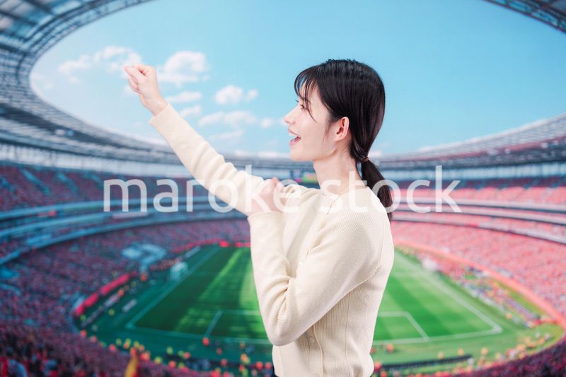スタジアムで応援をする若い女性