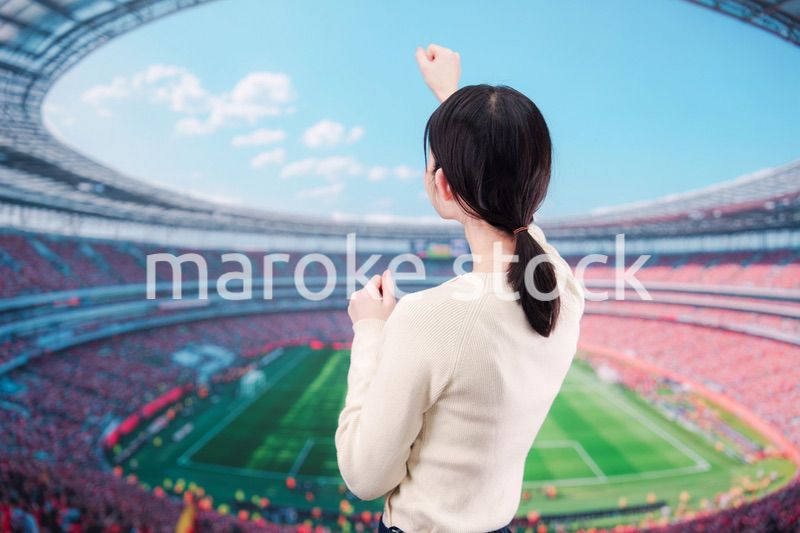 スタジアムで応援をする若い女性