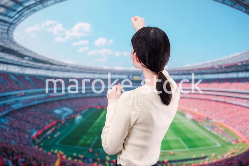 スタジアムで応援をする若い女性