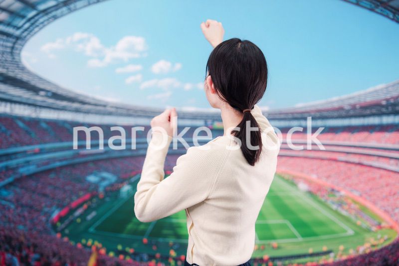 スタジアムで応援をする若い女性