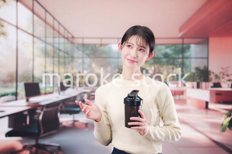 オフィスでマイボトルを持ち歩く若い女性