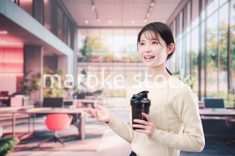 オフィスでマイボトルを持ち歩く若い女性