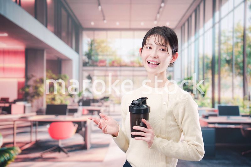 オフィスでマイボトルを持ち歩く若い女性