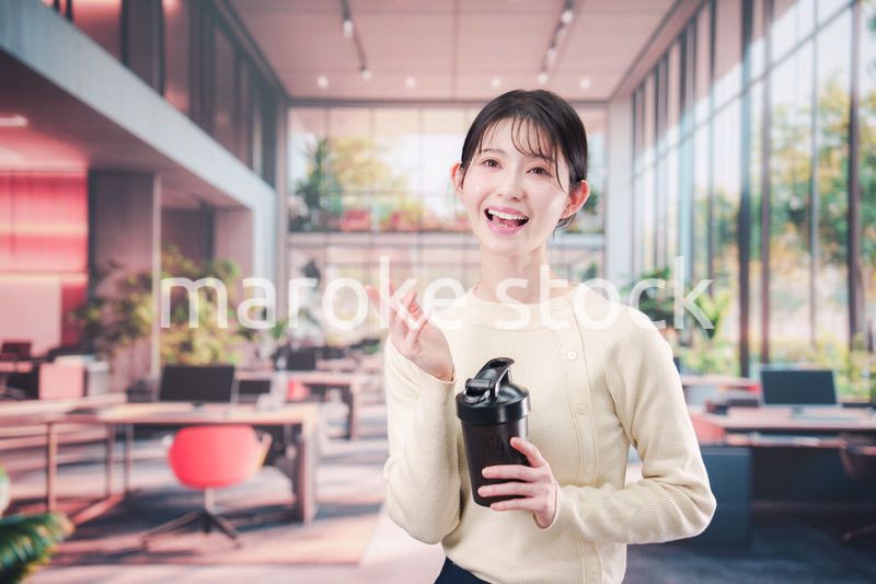 オフィスでマイボトルを持ち歩く若い女性
