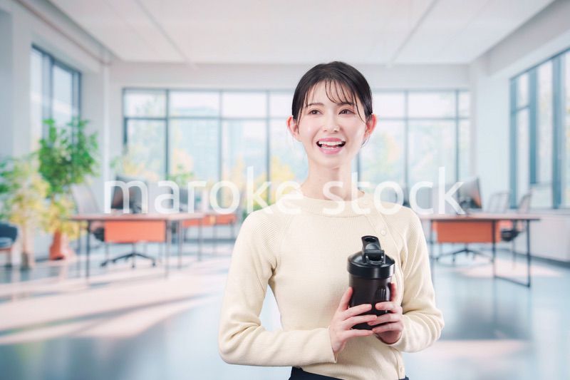オフィスでマイボトルを持ち歩く若い女性