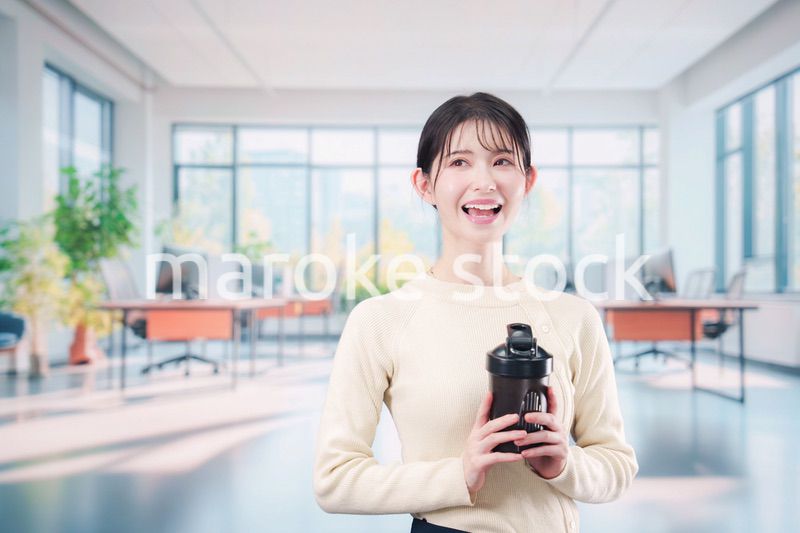 オフィスでマイボトルを持ち歩く若い女性