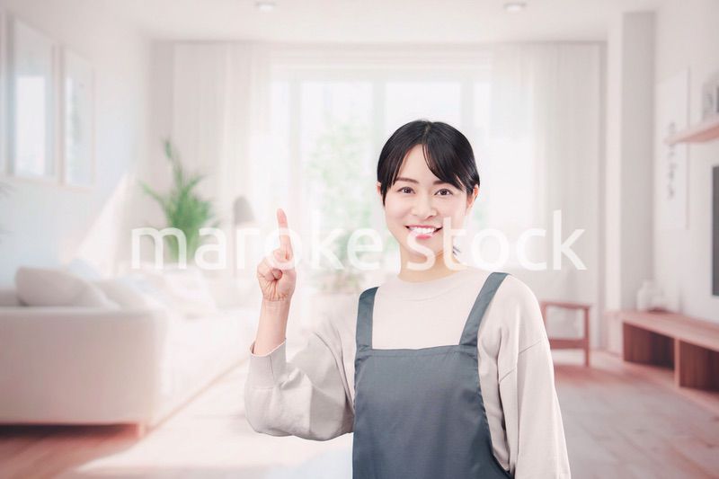 エプロンをしてお客様の家で働く家事代行の女性
