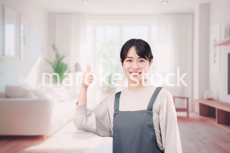 エプロンをしてお客様の家で働く家事代行の女性