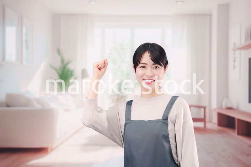 エプロンをしてお客様の家で働く家事代行の女性