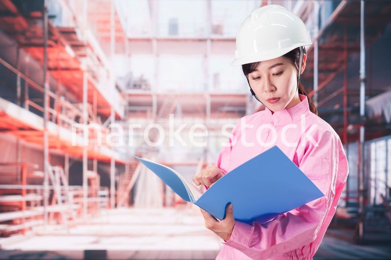 建設現場で確認をする女性の作業員