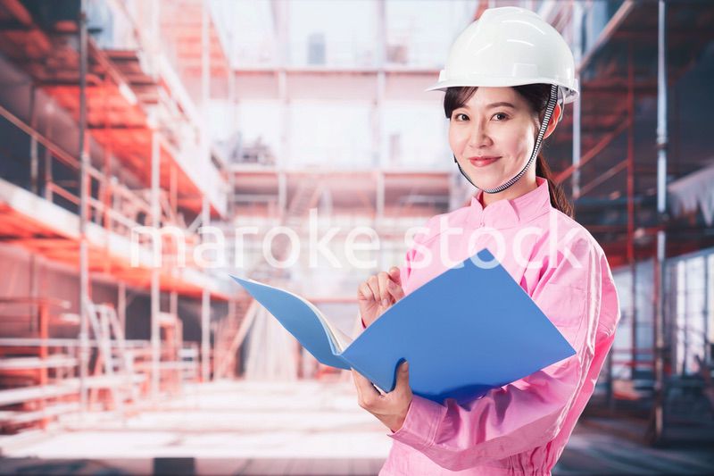 建設現場で確認をする女性の作業員