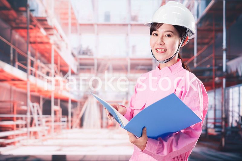 建設現場で確認をする女性の作業員