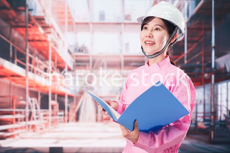 建設現場で確認をする女性の作業員