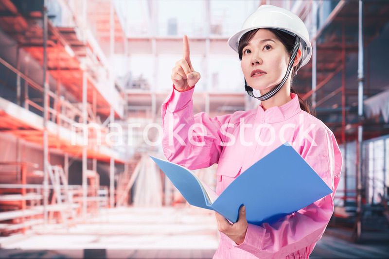 建設現場で確認をする女性の作業員