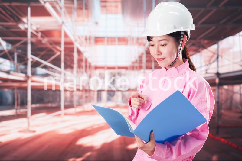 建設現場で確認をする女性の作業員