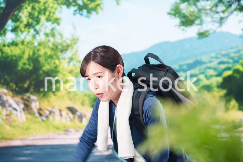 アウトドアでバテる若い女性