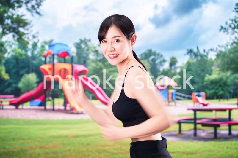 公園でランニングをする若い女性