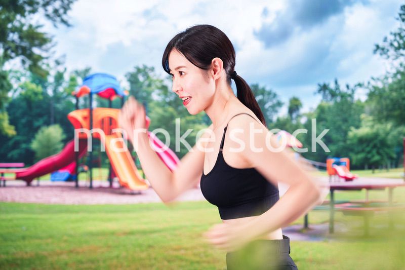 公園でランニングをする若い女性