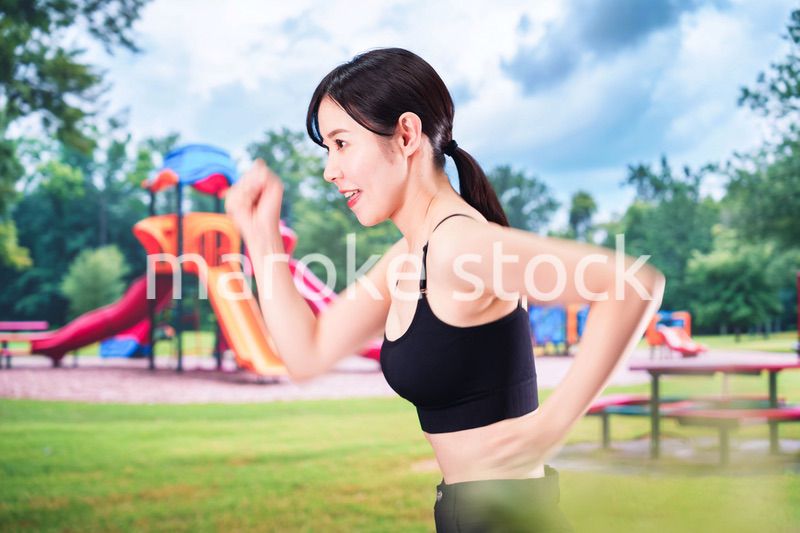 公園でランニングをする若い女性