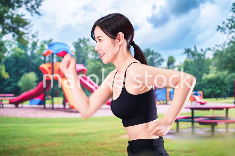 公園でランニングをする若い女性