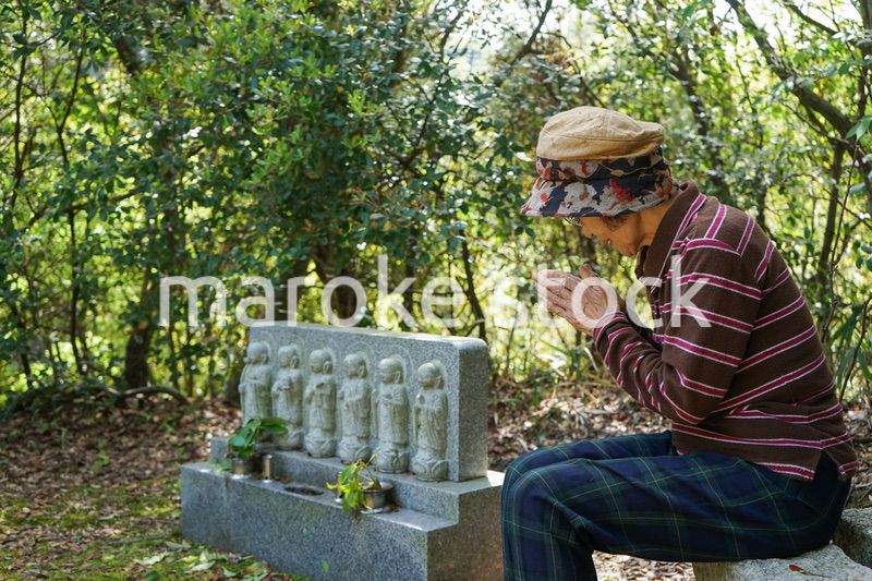 お墓参りをする高齢者