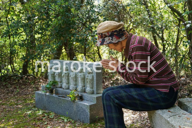 お墓参りをする高齢者