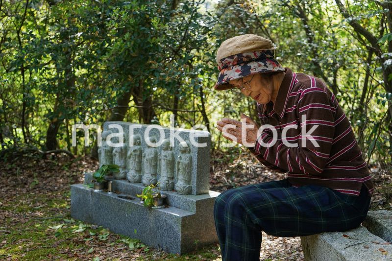 お墓参りをする高齢者