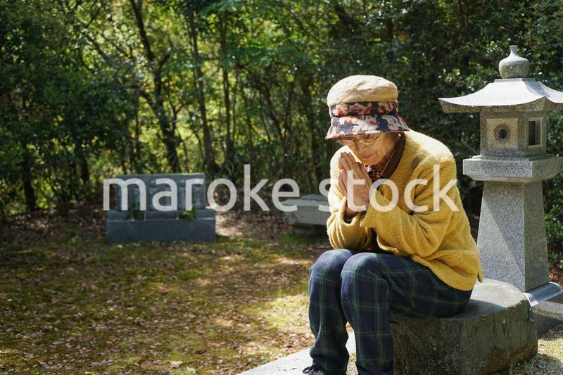 お墓参りをする高齢者