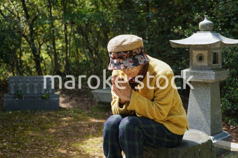 お墓参りをする高齢者