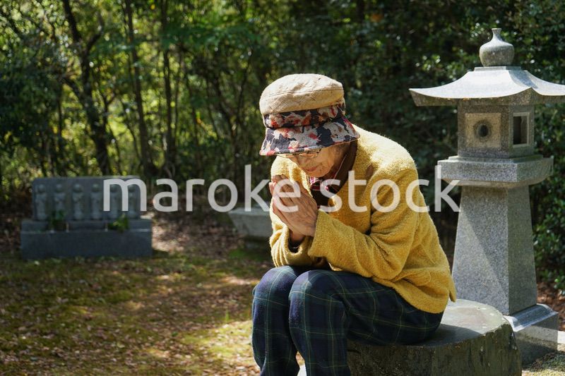 お墓参りをする高齢者
