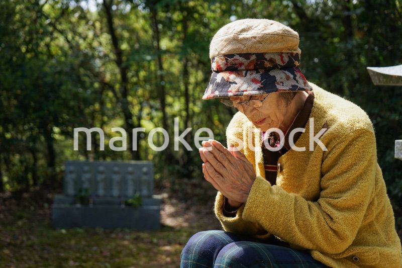 お墓参りをする高齢者