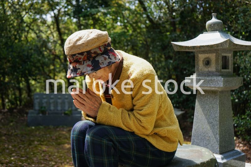 お墓参りをする高齢者