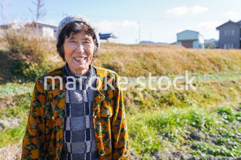 田舎でほほえむ高齢の女性