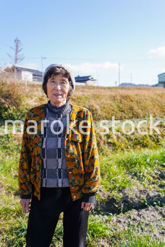 田舎でほほえむ高齢の女性