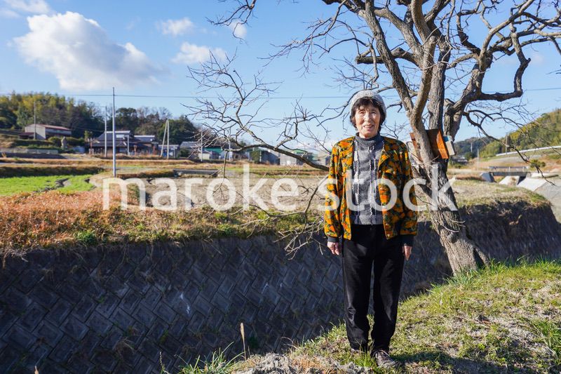田舎でほほえむ高齢の女性