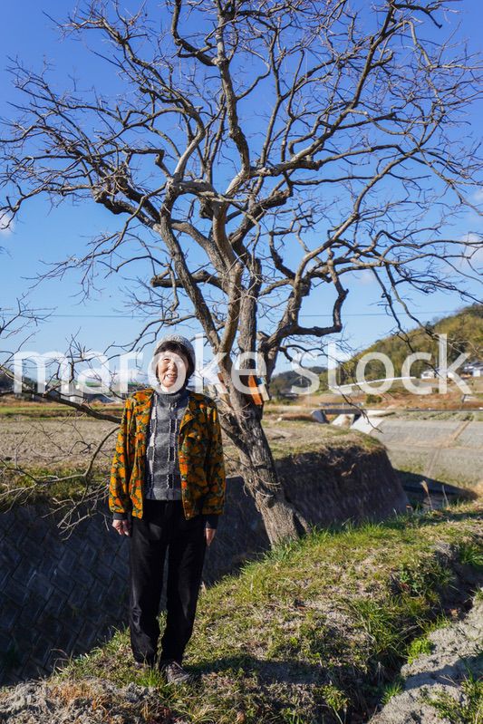 田舎でほほえむ高齢の女性