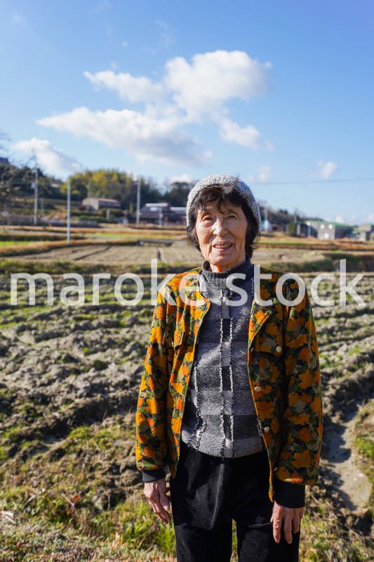田舎でほほえむ高齢の女性
