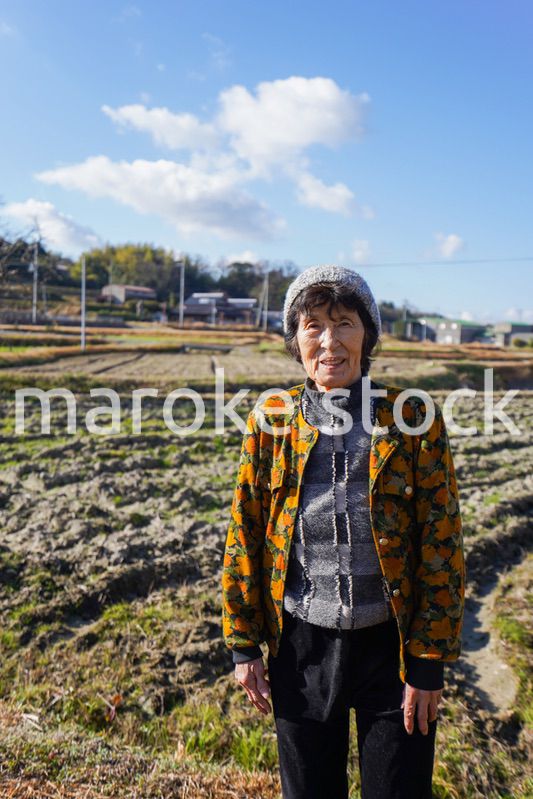 田舎でほほえむ高齢の女性
