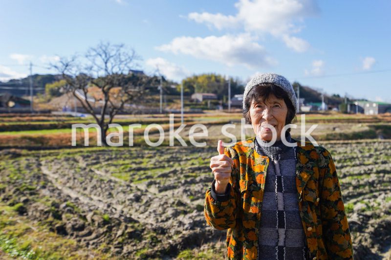 田舎でグッドサインをする高齢の女性