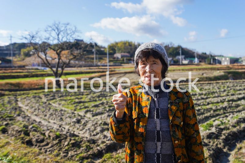 田舎でグッドサインをする高齢の女性