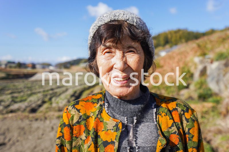 田舎でほほえむ高齢の女性