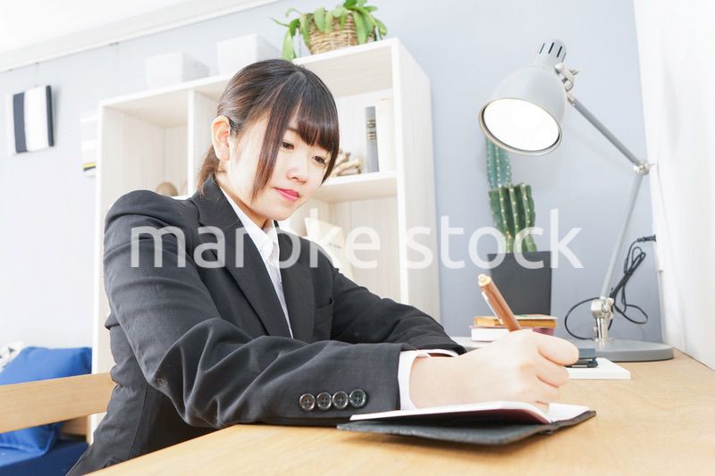 スーツを着て勉強をする女性